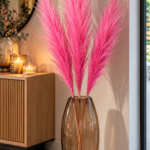 Getrocknetes Pampasgras in kräftigem Pink mit drei langen Stielen als moderne Wohnzimmerdekoration.